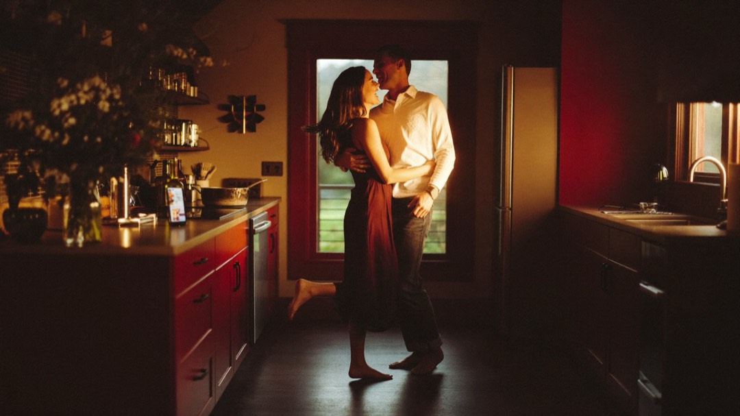 A couple slow dancing in their kitchen while their song plays